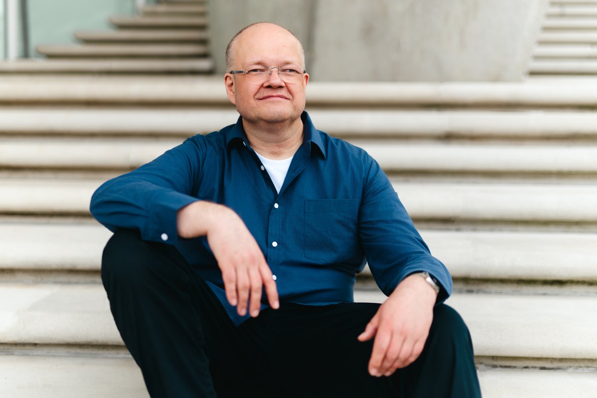 Roland Kruse auf einer Treppe sitzend
